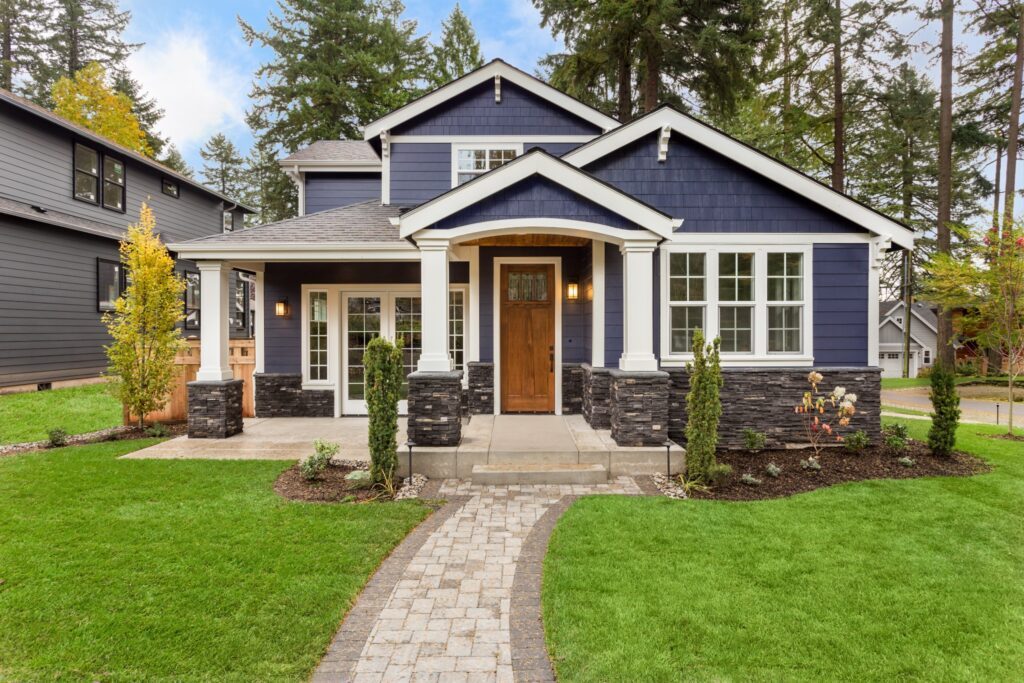 Navy blue craftsman home with white trim and a stone walkway