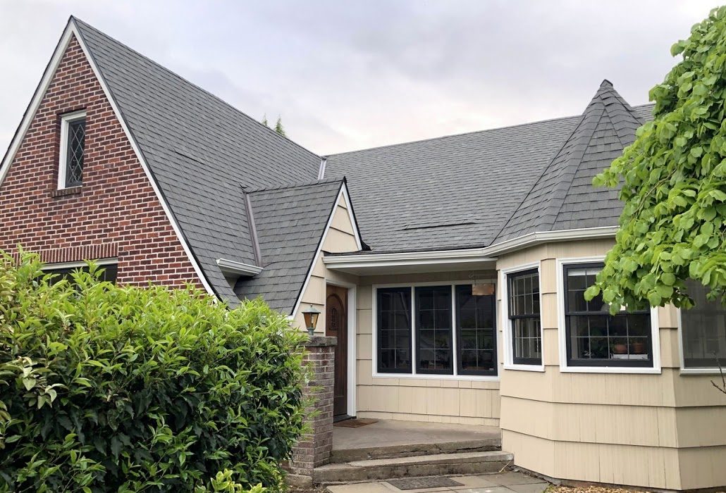 Tudor-style house before painting, with tan siding